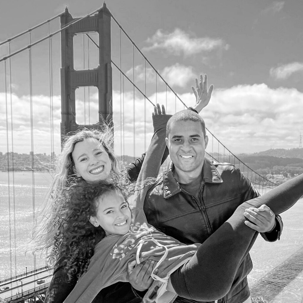 Family founders of TheClickMedia smiling together in front of the Golden Gate Bridge, symbolizing teamwork and shared mission.